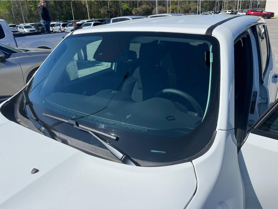 Technician installing a replacement windshield on a vehicle in Lake City, SC